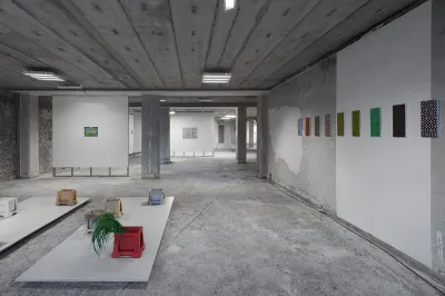 View of artworks displayed in an unfinished office building.
