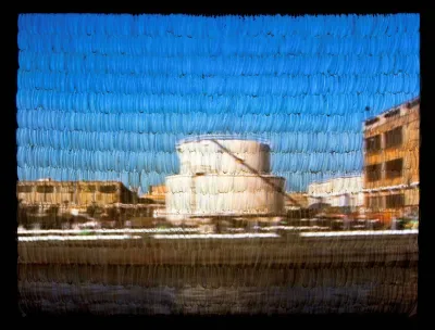 View of a video projection onto a screen of sewn-together white turkey feathers.